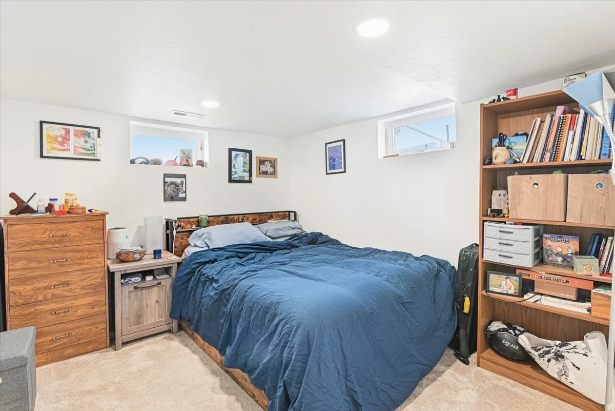 Carpeted room featuring recessed lighting, a built-in bookshelf, and two high-set windows providing natural light