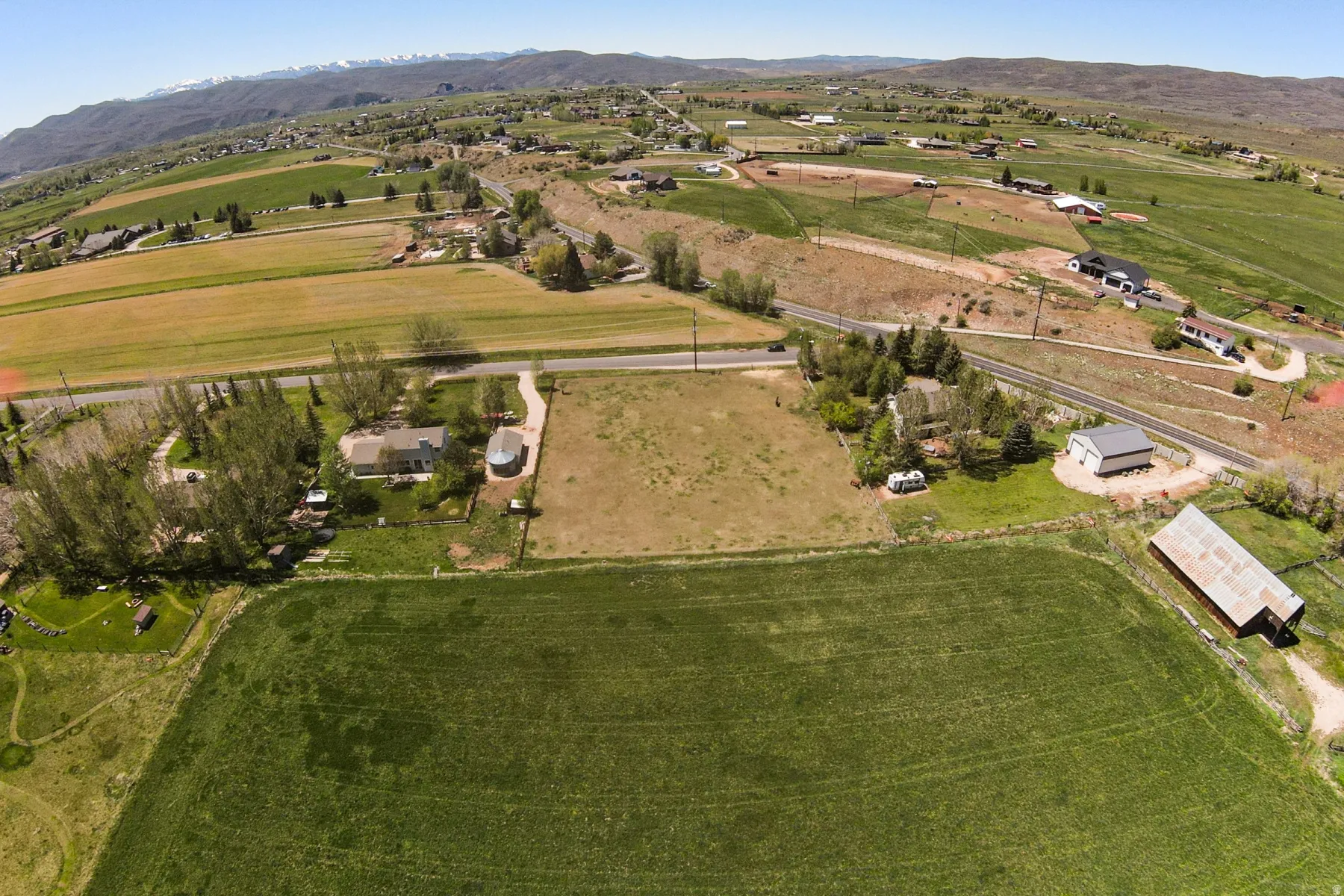 Expansive land parcel featuring multiple structures including a single-story residence, a large barn, and an outbuilding