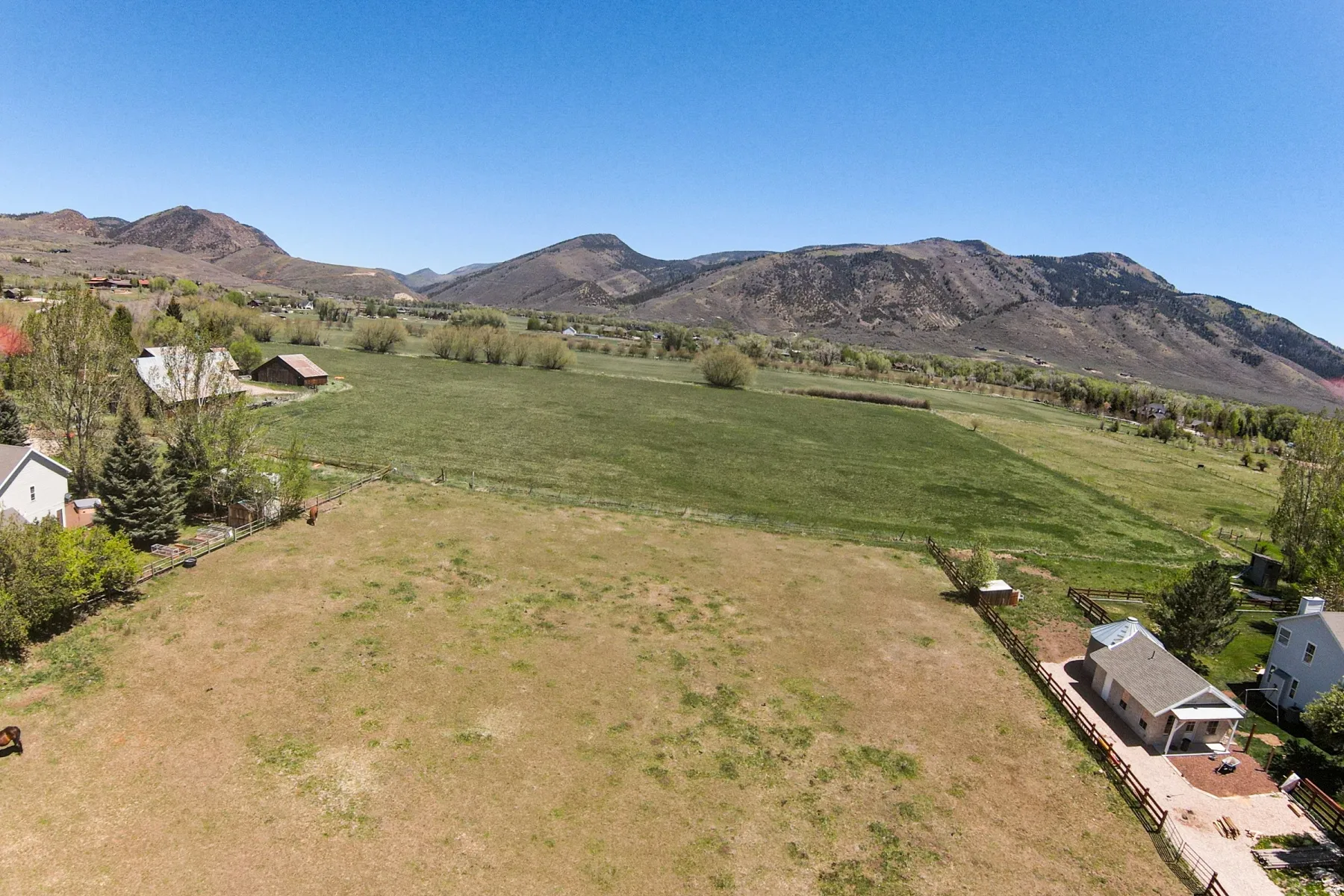 Expansive land parcel featuring open fields and distant mountain ranges