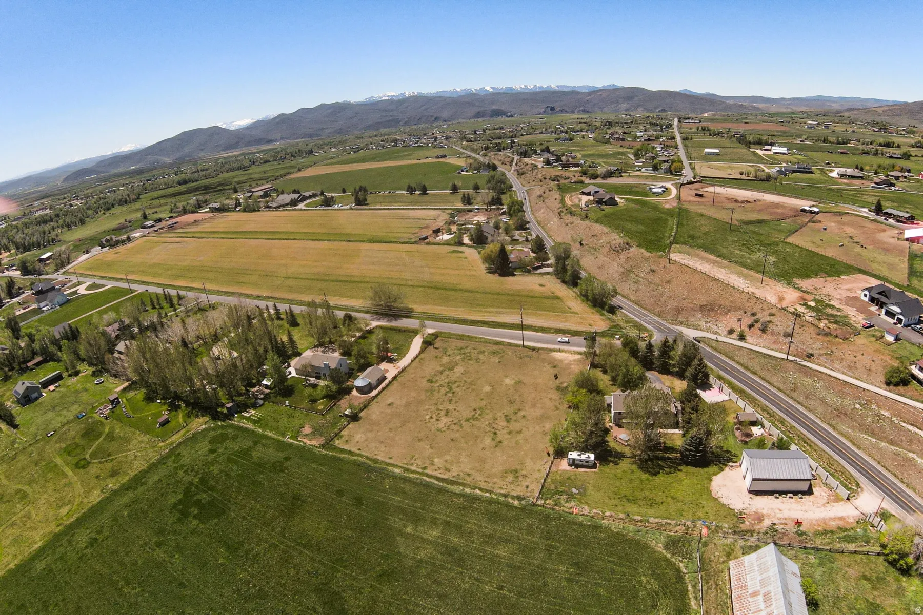 Expansive rural landscape featuring agricultural fields and scattered residential properties