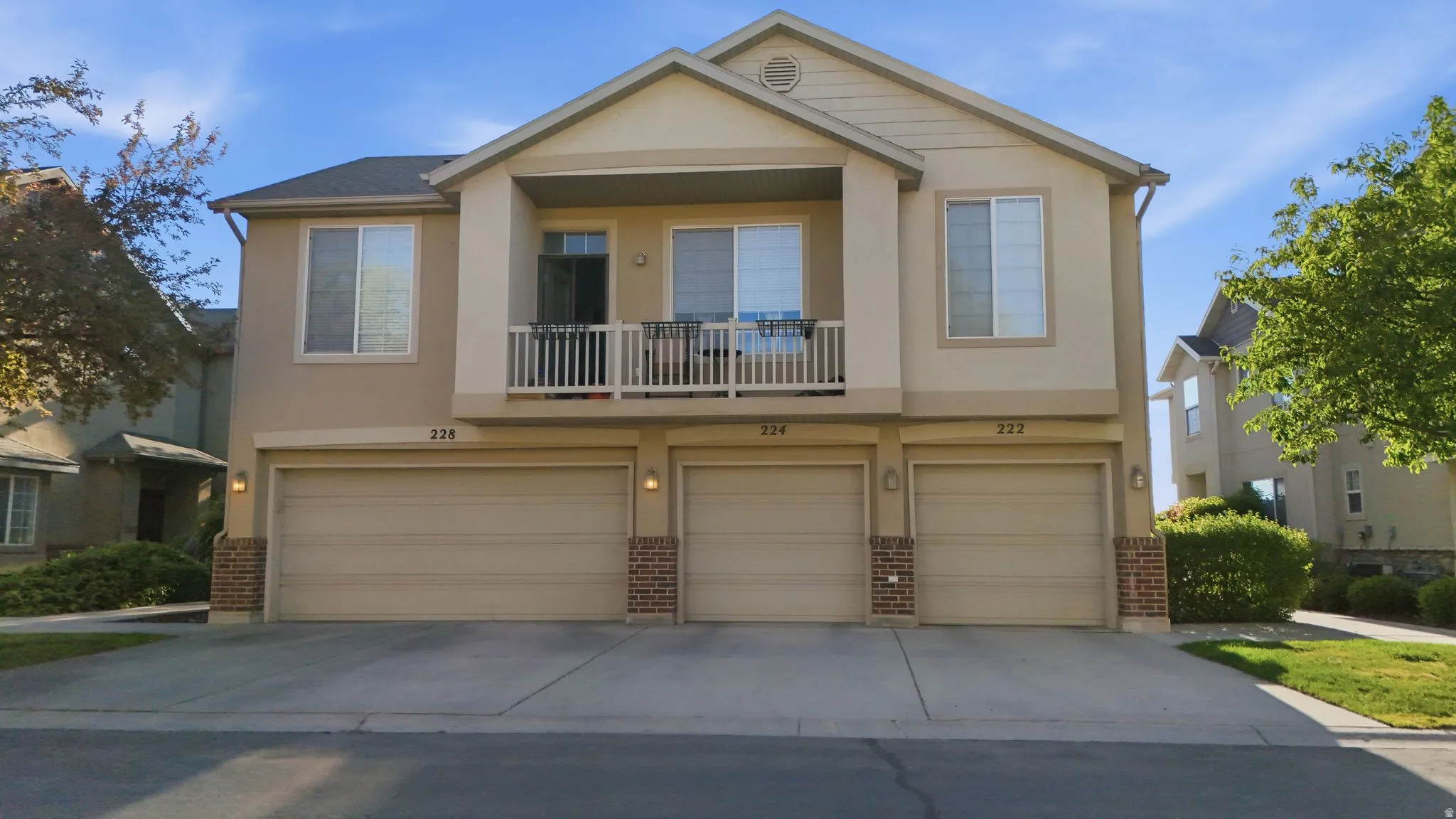 Contemporary multi-unit residence featuring neutral-toned stucco siding and individual garage doors