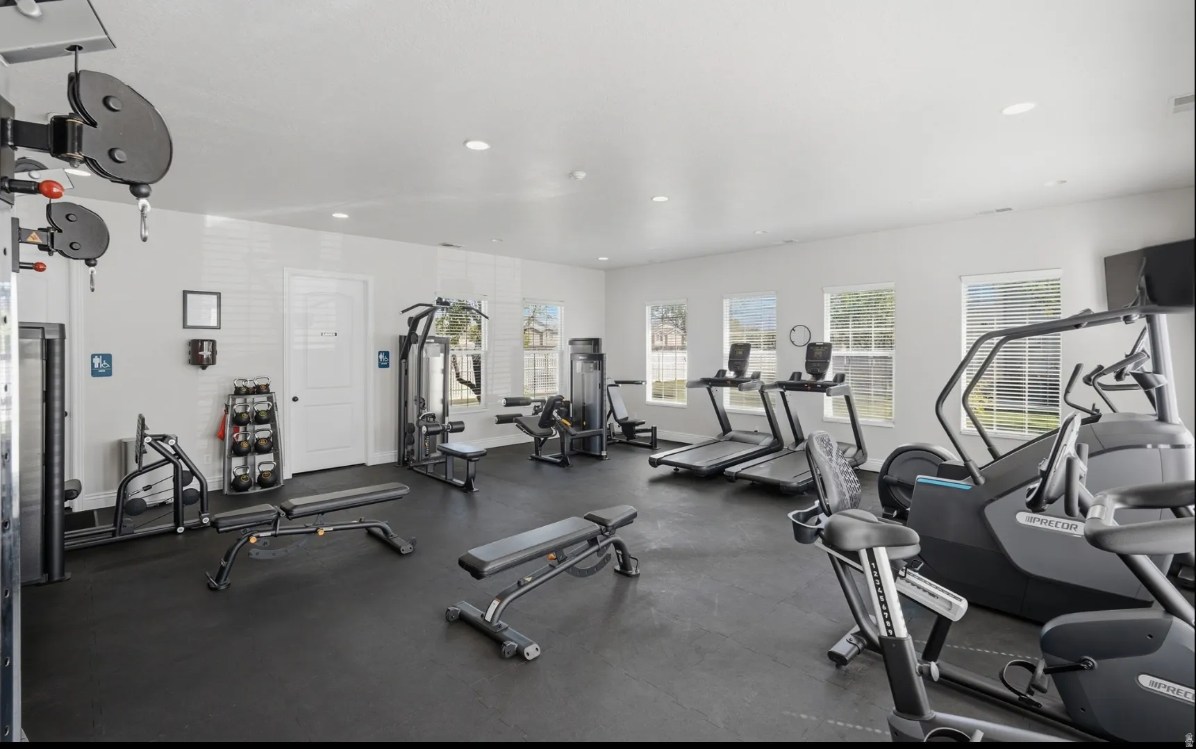 Fitness center featuring rubber flooring, recessed lighting, and multiple windows