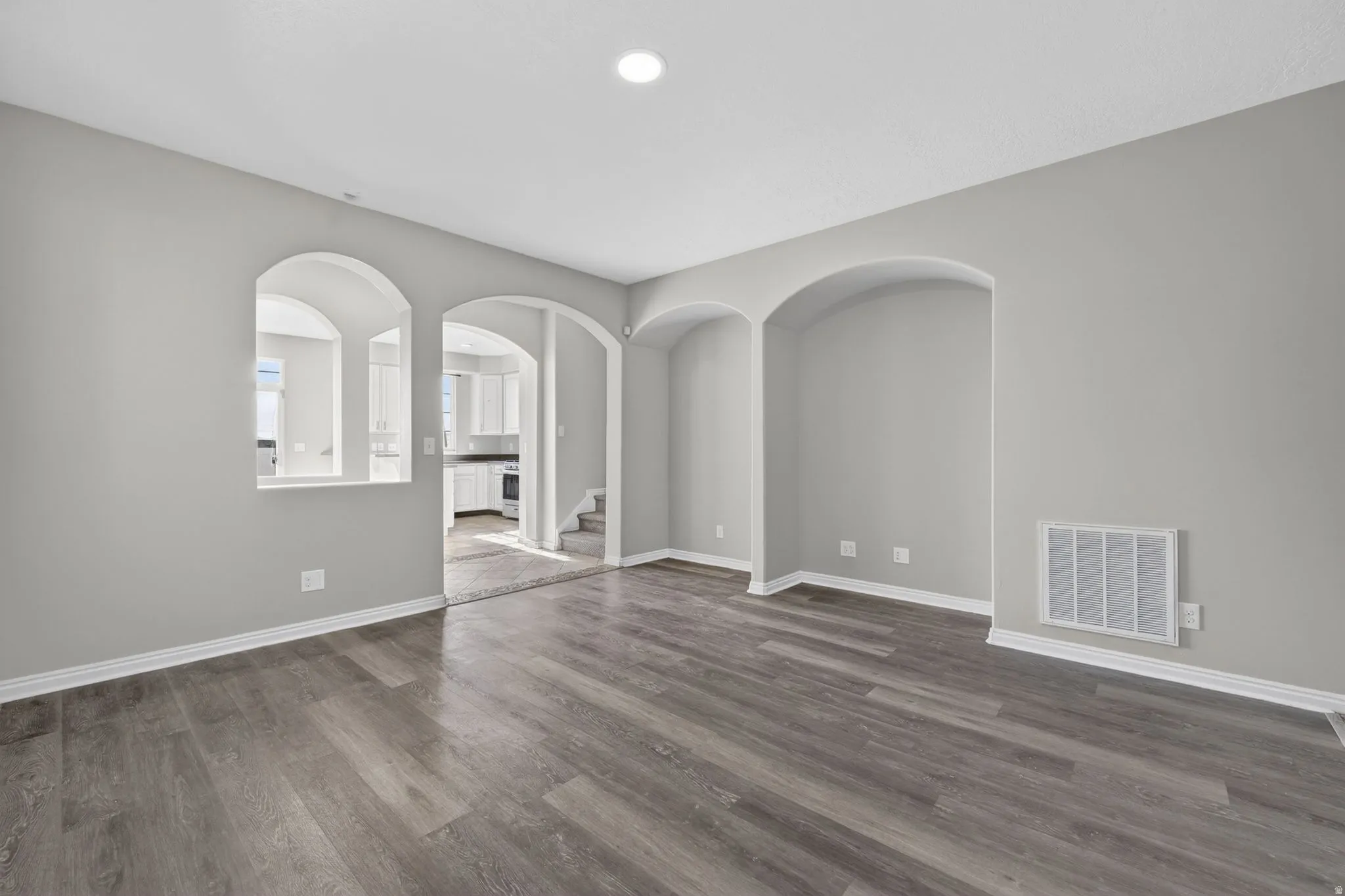 Interior space featuring wood-finish flooring, light grey painted walls, and white baseboards