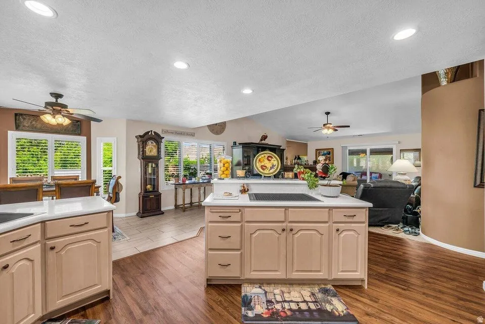 Kitchen featuring an island with a built-in cooktop, light-toned cabinetry, and solid surface countertops