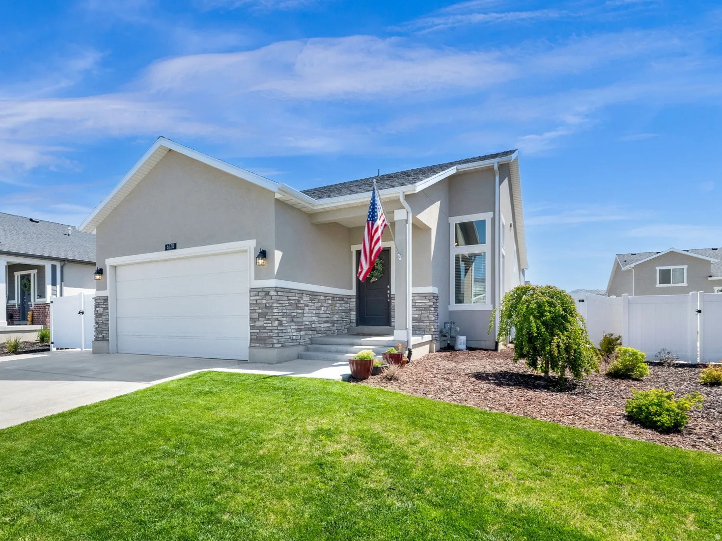 Contemporary exterior featuring light gray stucco and a stone facade