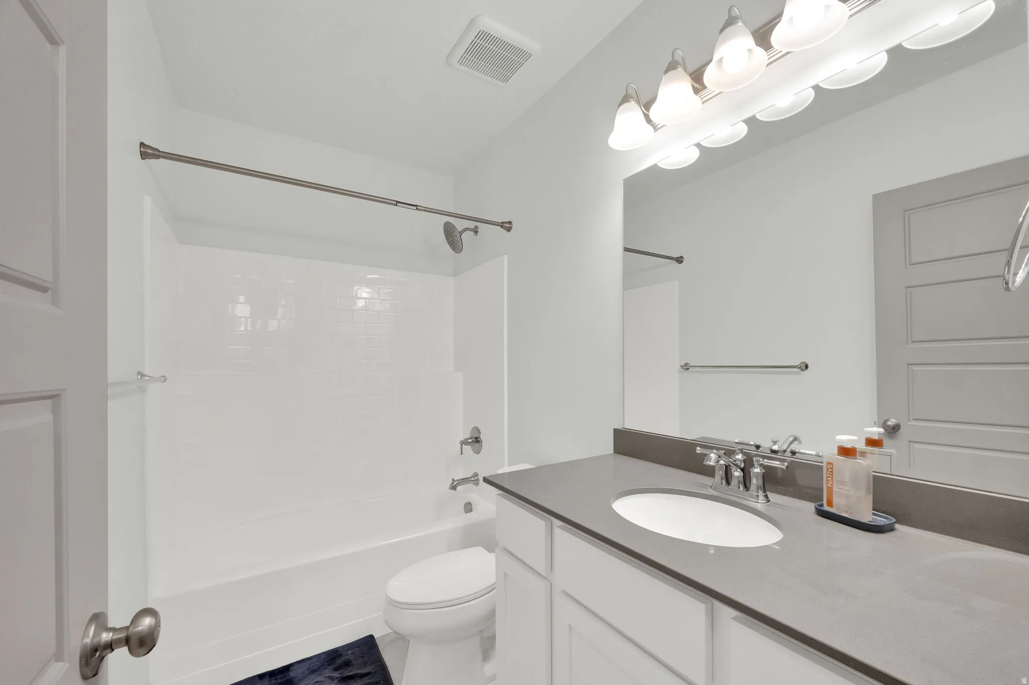 Bathroom featuring a vanity with an integrated sink, a gray countertop, and white cabinetry