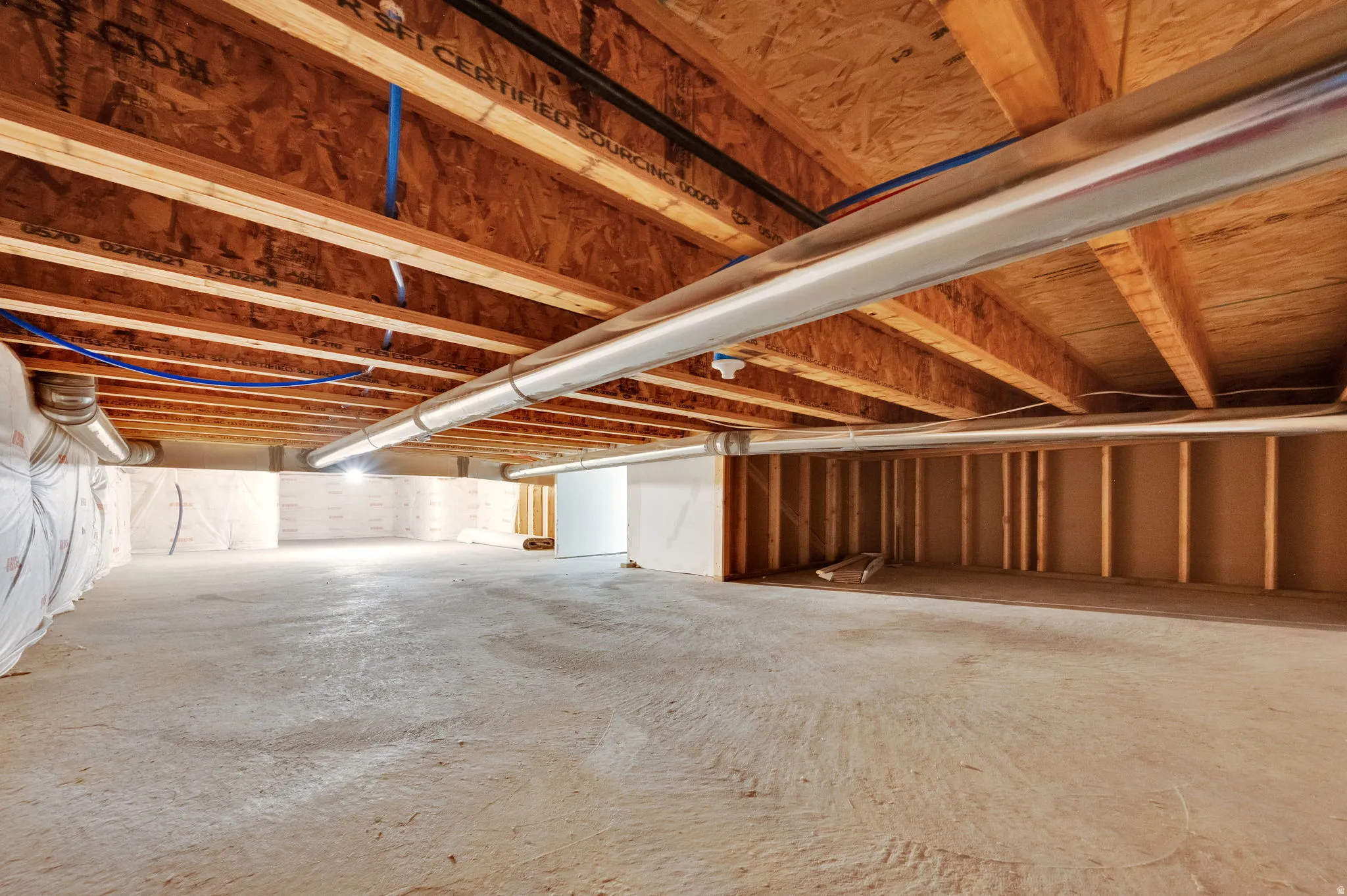 Unfinished crawl space with concrete flooring and framed wall sections