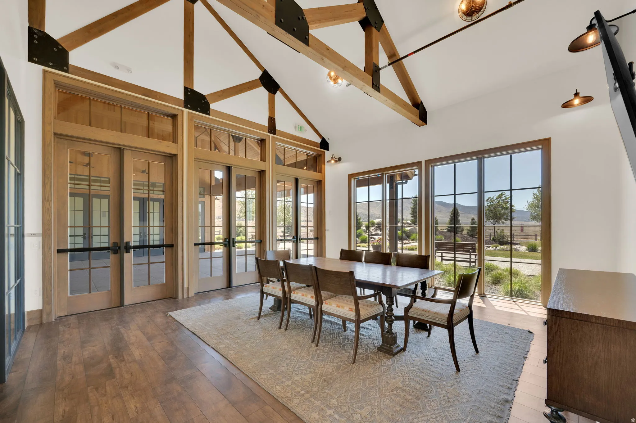 Vaulted ceiling with exposed wood beams and industrial-style lighting