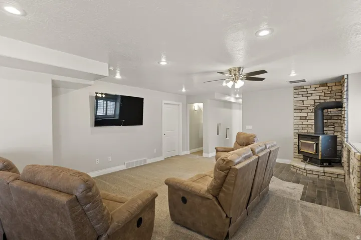 Living area featuring a stone accent wall with a wood-burning stove,