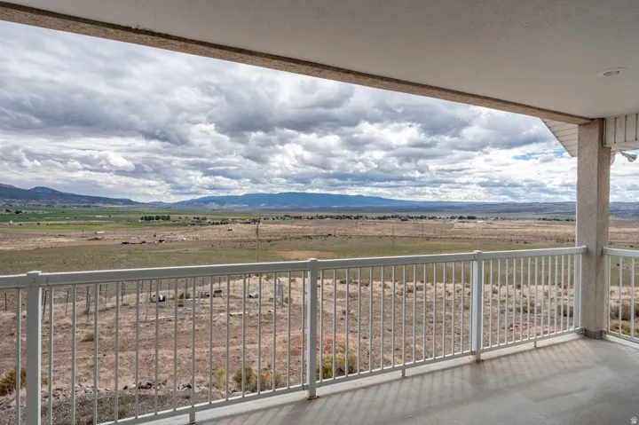 Covered deck overlooking expansive agricultural lands and distant mountains