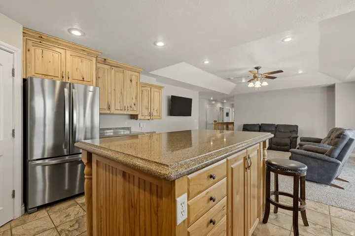 Kitchen island featuring a granite countertop and natural wood cabinetry