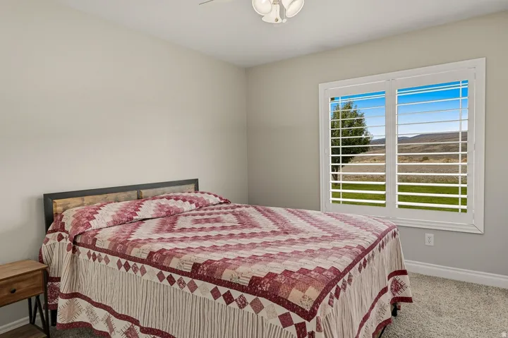 Bedroom featuring a window with white plantation shutters and mountain view