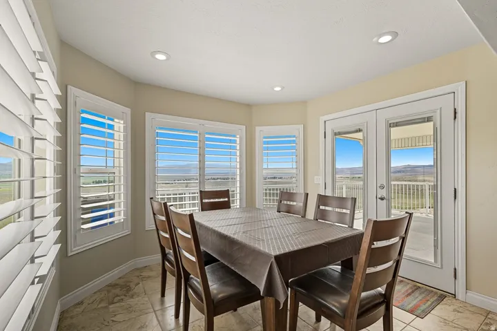 Dining area with tile flooring and a bay window featuring plantation shutters