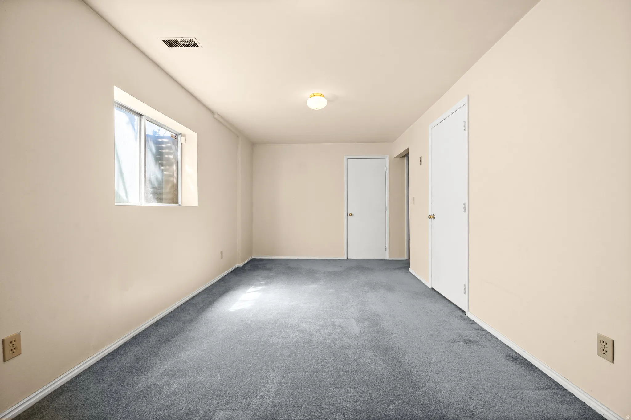 Cream-painted walls complement the deep gray carpeting