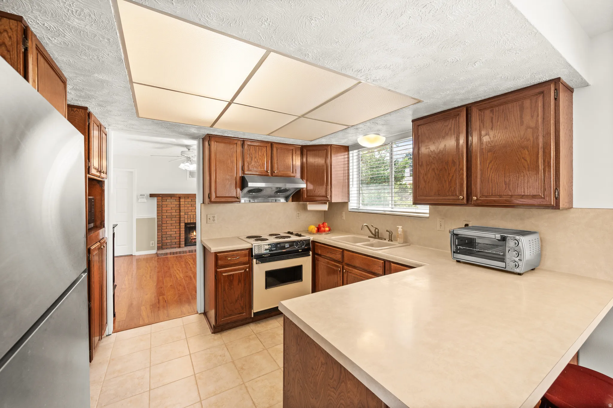 Efficient kitchen featuring wood-finish cabinetry and light-toned countertops