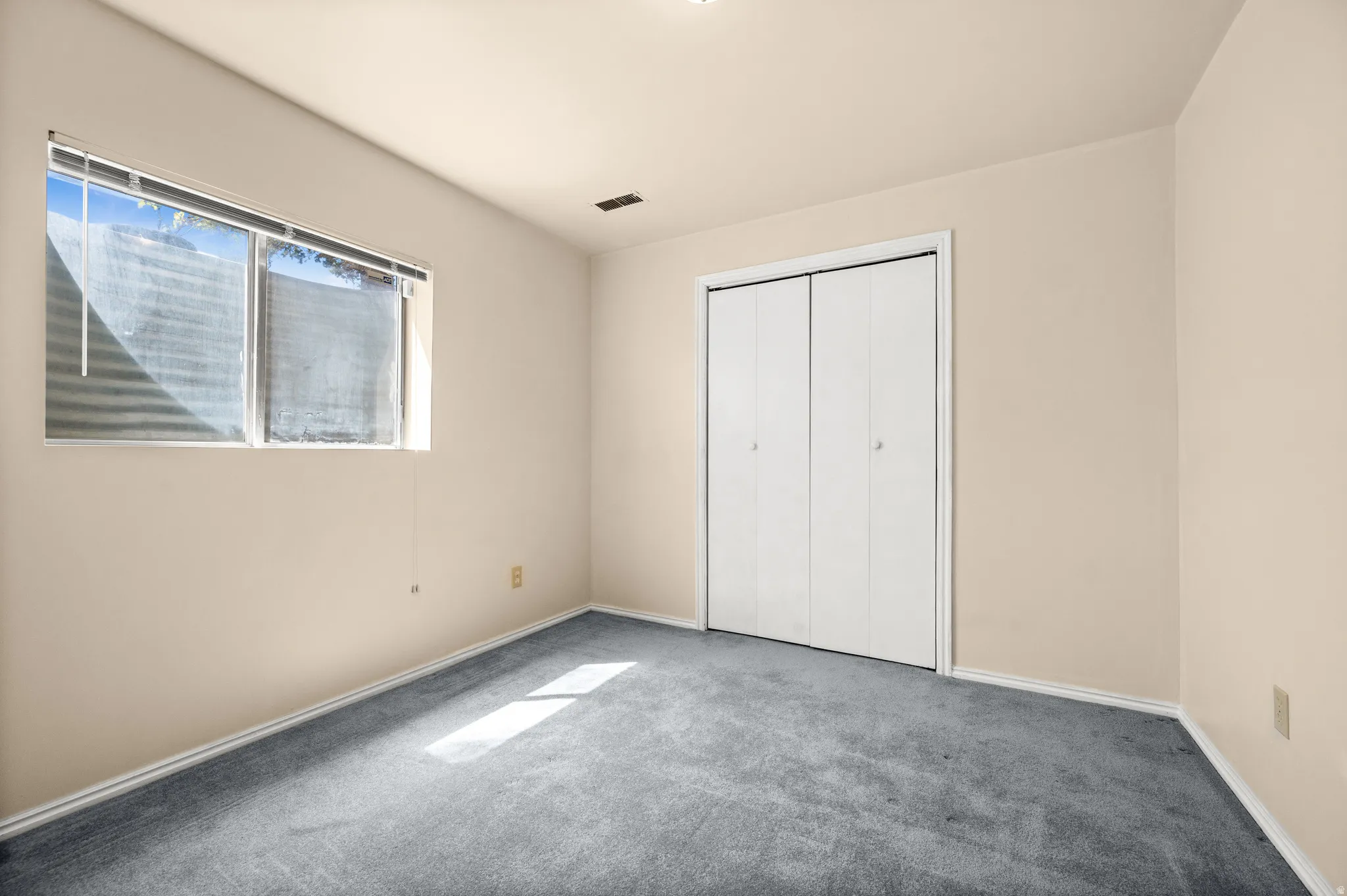 Neutral tone wall finishes with light gray carpeting