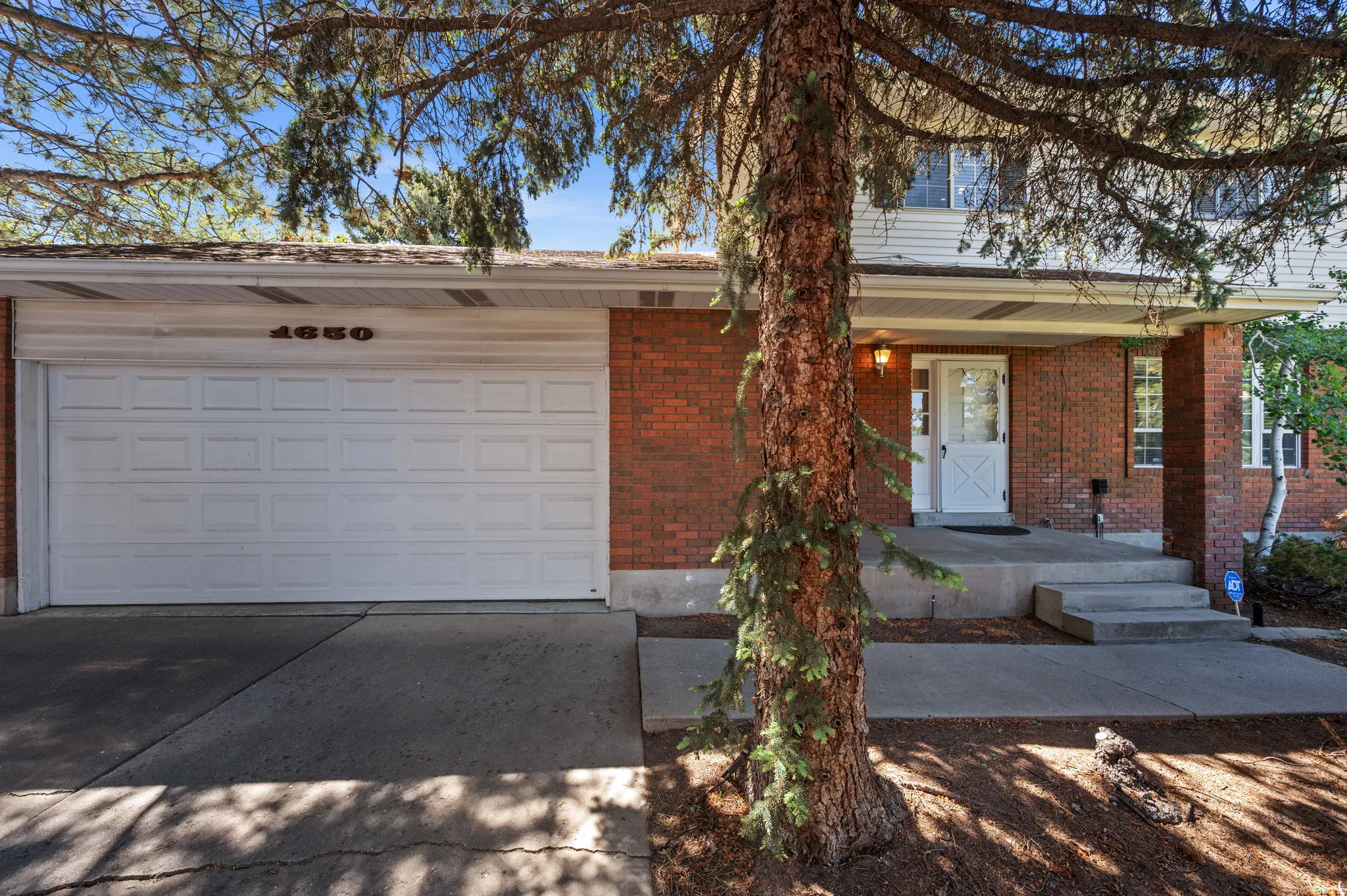 Brick exterior with white siding accents and a covered front porch entry