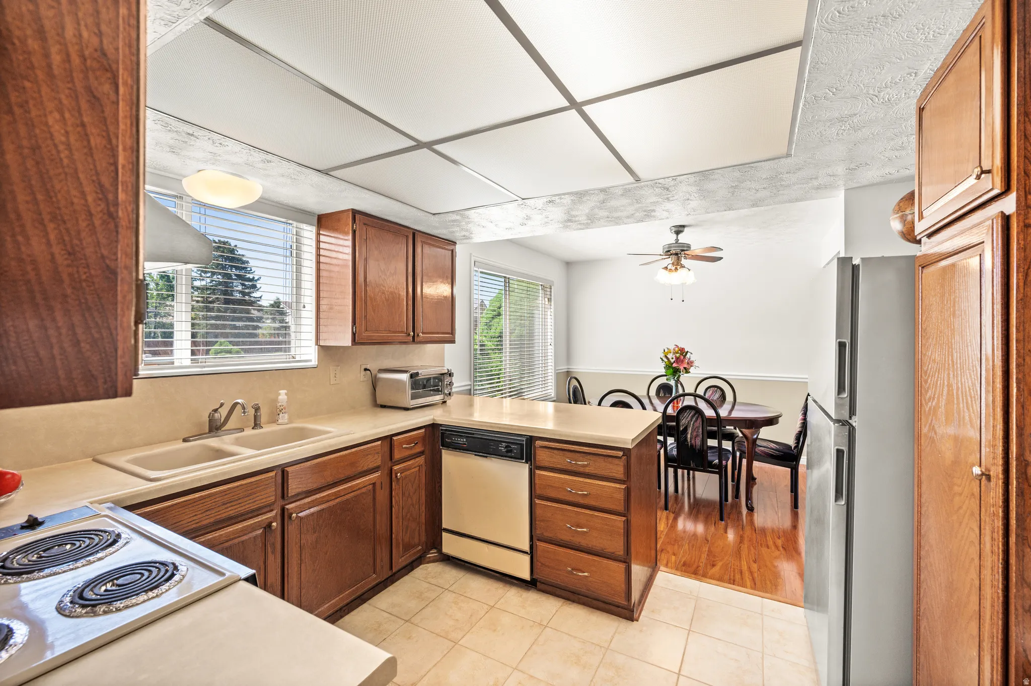 Kitchen featuring wood cabinetry, integrated double sink, and a four-burner electric range