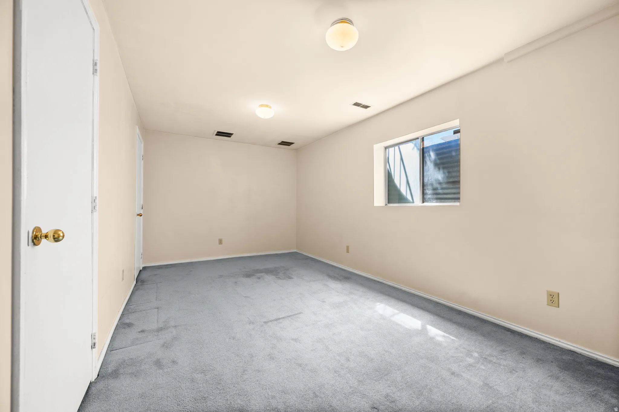 Room featuring light-colored walls and blue-gray carpeting