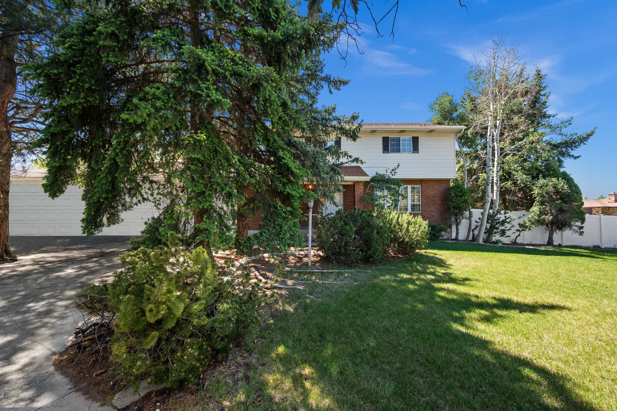 Traditional two-story residence featuring a brick and siding exterior, an attached two-car garage, and a manicured front lawn