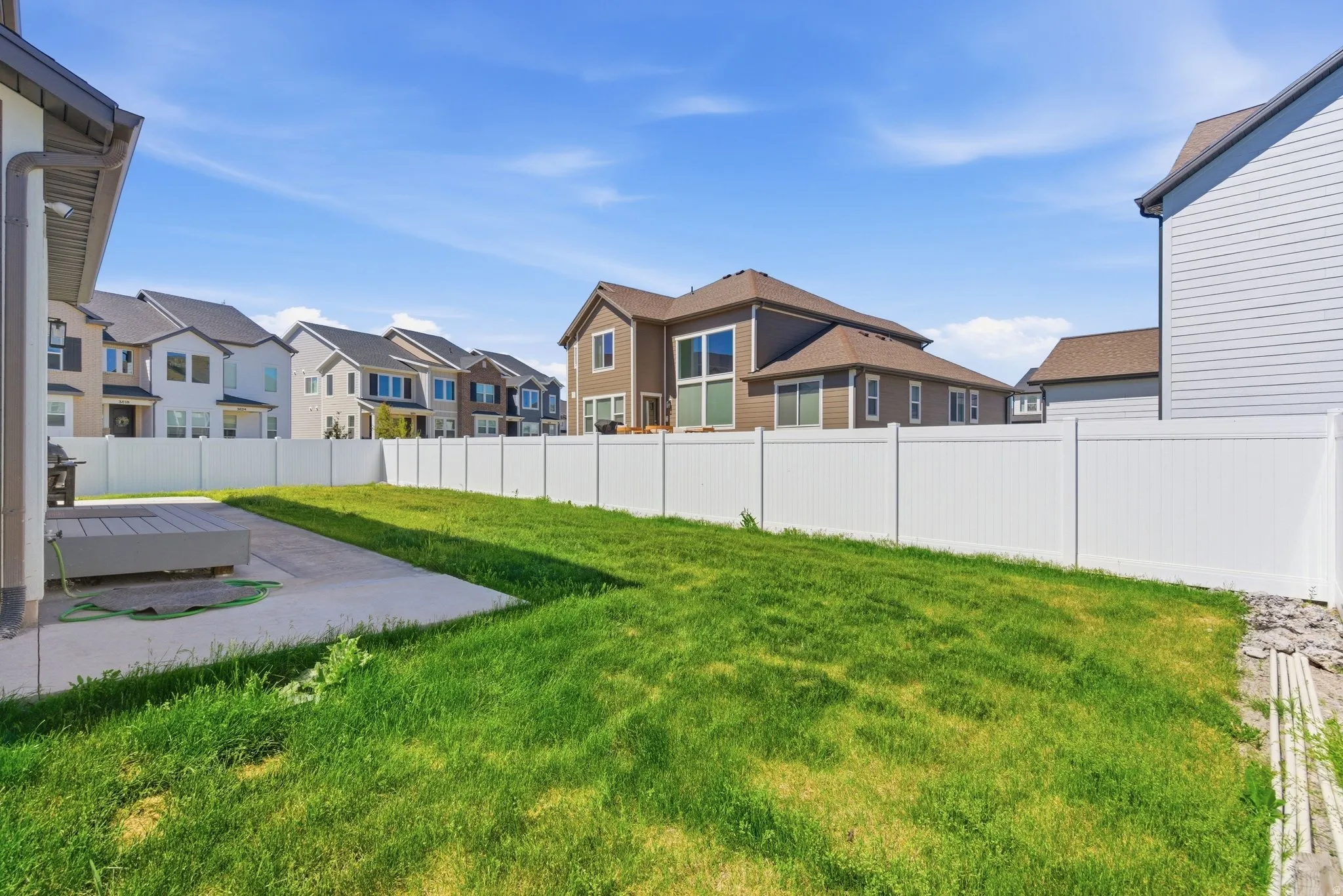 Generous backyard featuring a concrete patio, composite decking, and a full privacy fence