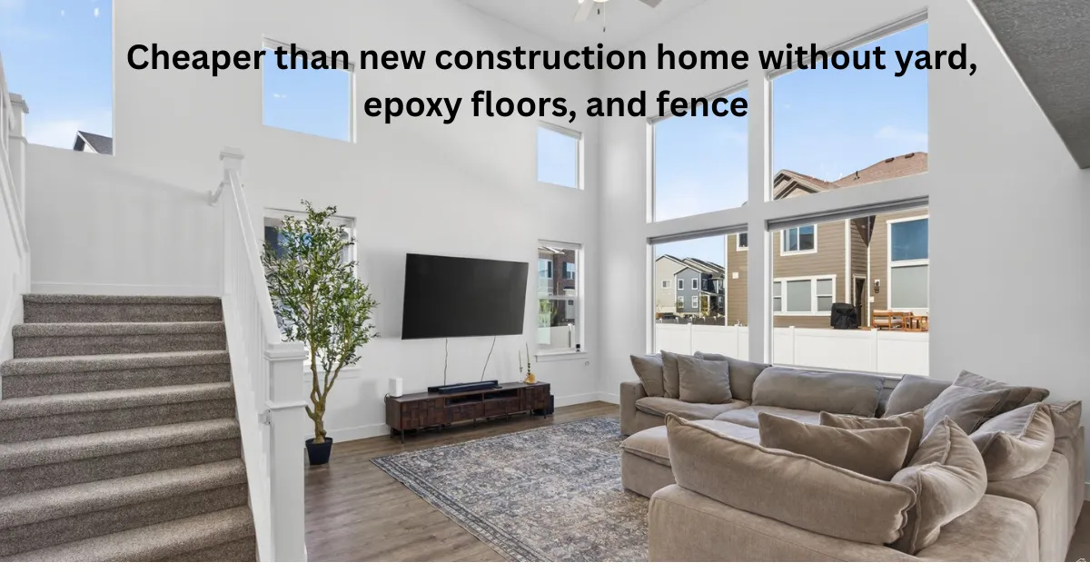 Two-story living area with high ceilings, large windows, LVP flooring, and a carpeted staircase