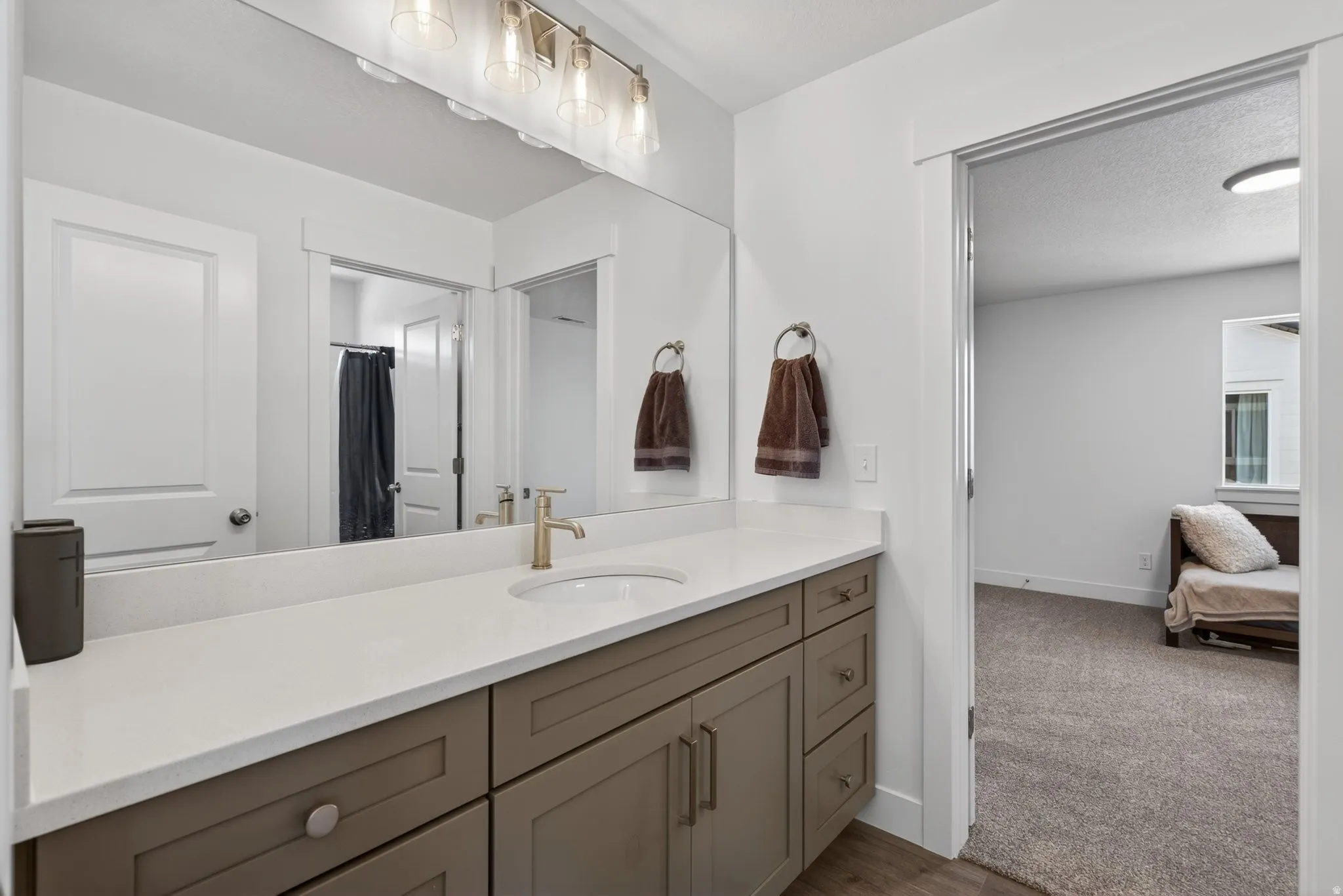 Spacious Jack and Jill bathroom vanity featuring a light quartz countertop, undermount sink