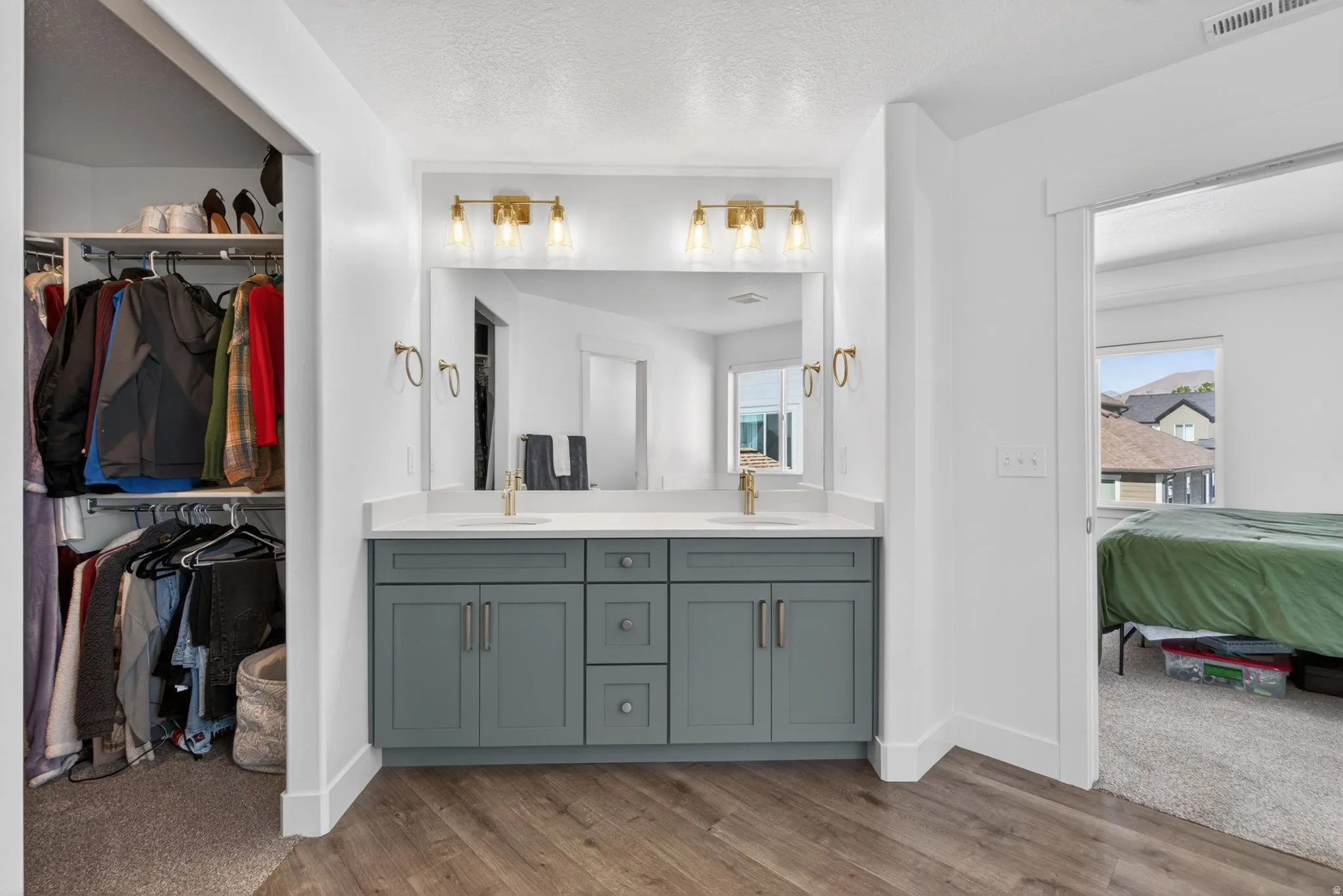 Dual vanity featuring a white countertop, undermount sinks, in primary bedroom