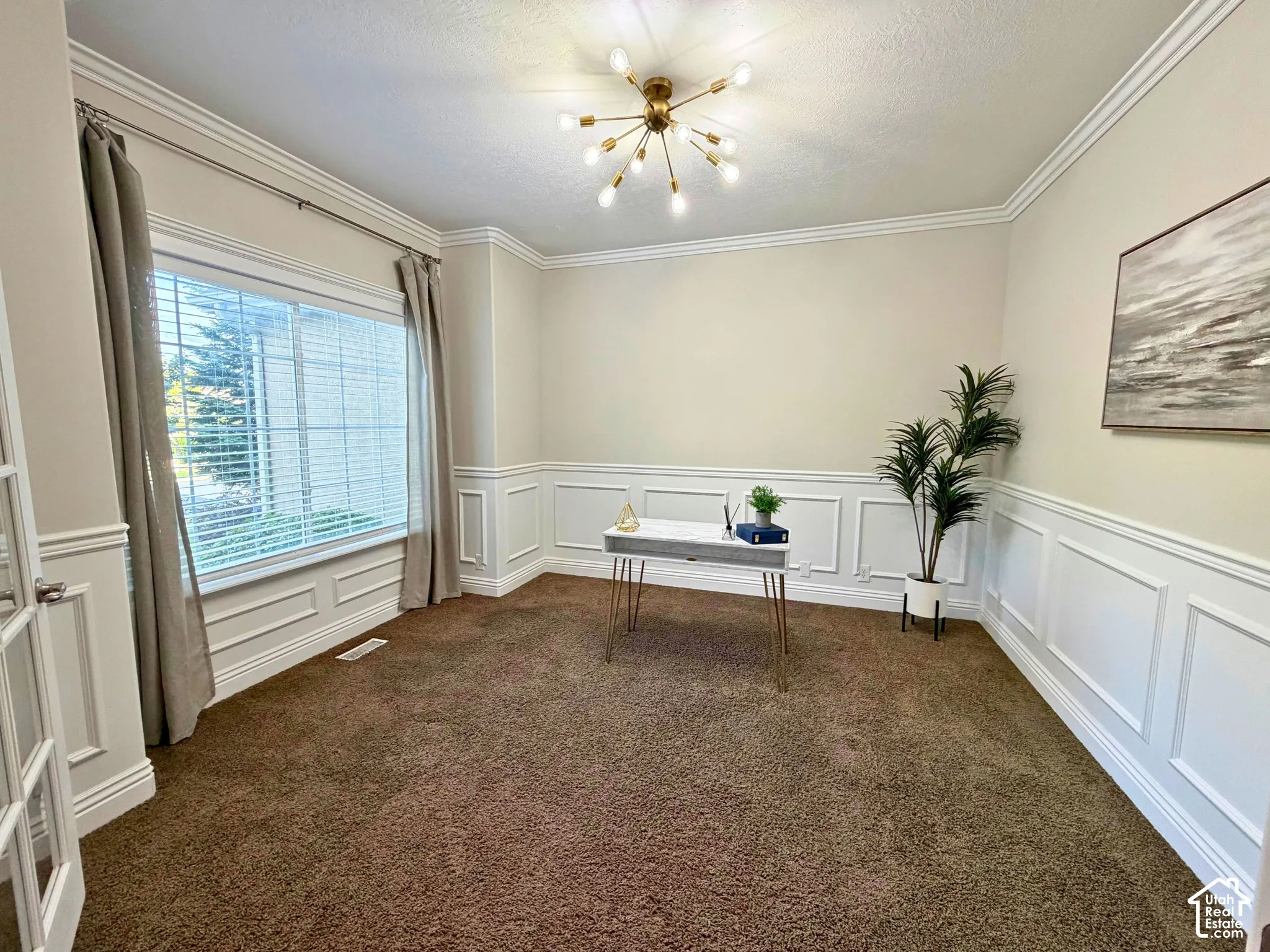 Crown molding and wainscoting detailing enhance the room