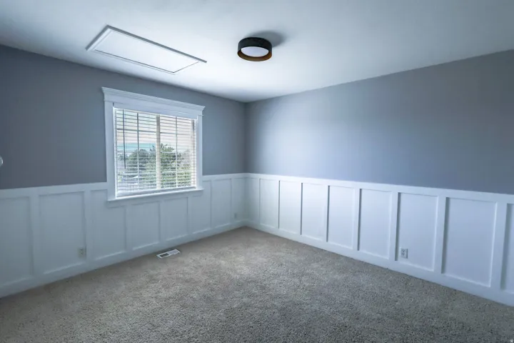 Interior room featuring two-tone walls with white board and batten wainscoting and light gray paint
