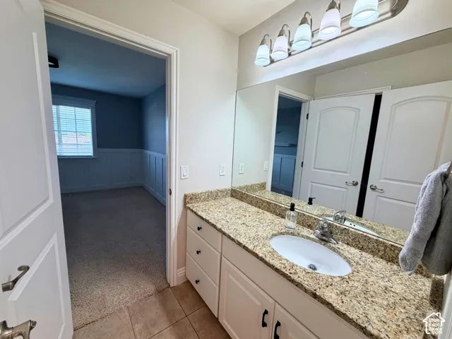 Vanity with an integrated sink, granite-look countertop, and a four-light fixture
