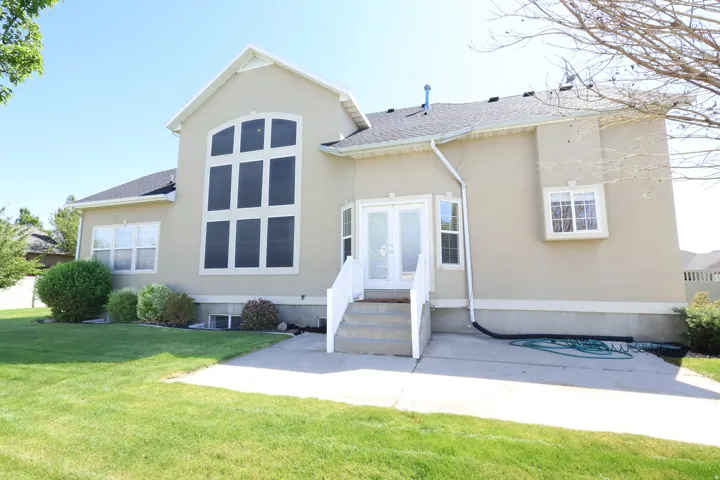 Stucco exterior featuring a prominent multi-pane arched window