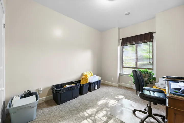 Carpeted room with a window featuring horizontal blinds and a fabric valance