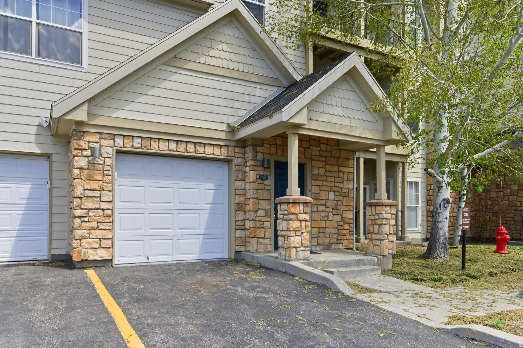 Exterior featuring stone veneer accents, horizontal siding, and multiple gabled rooflines