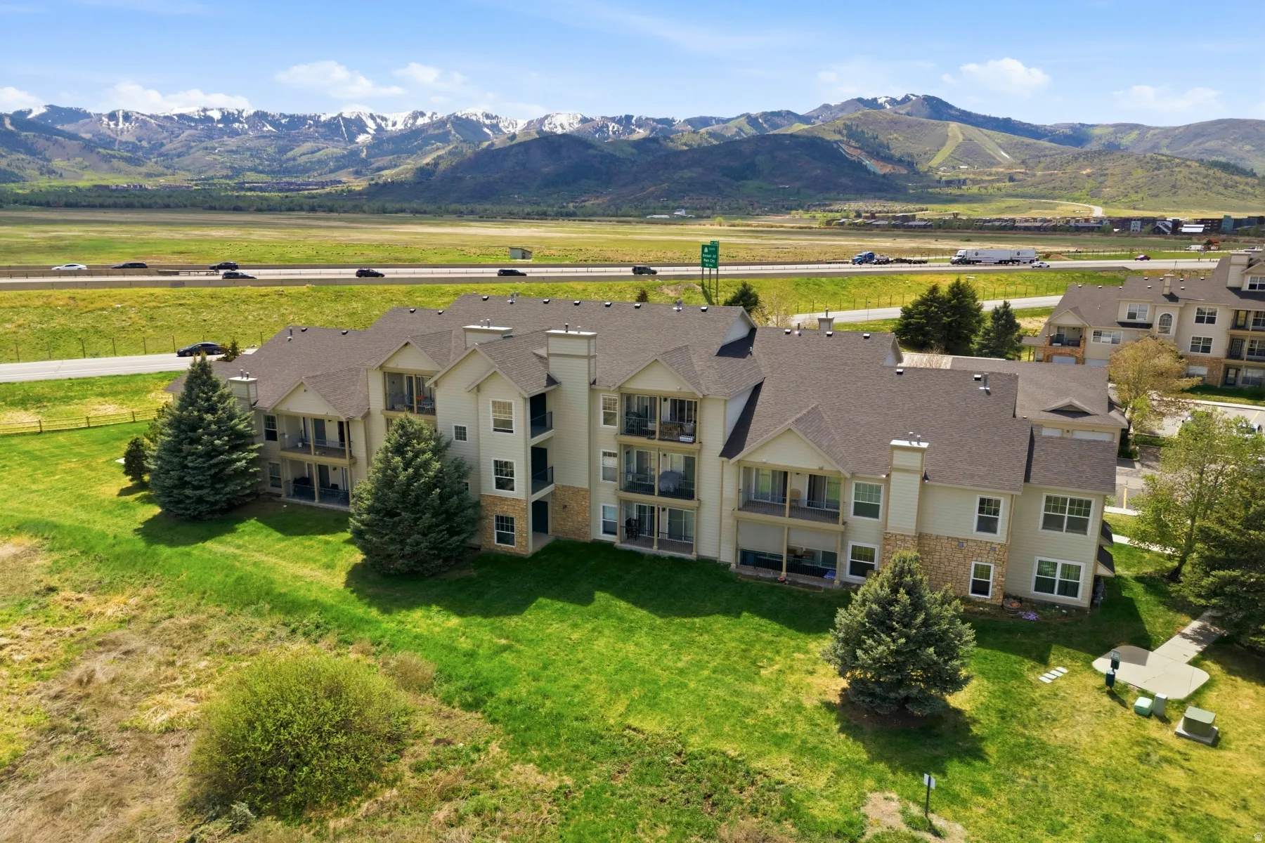 Multi-story residential building with light-toned siding and stone accents