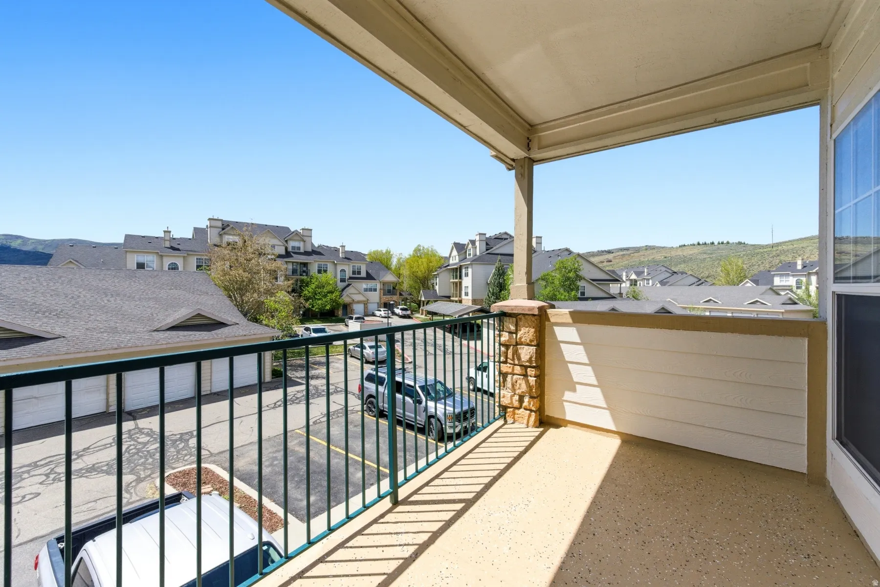 Covered balcony with a textured flooring, offering an expansive outlook