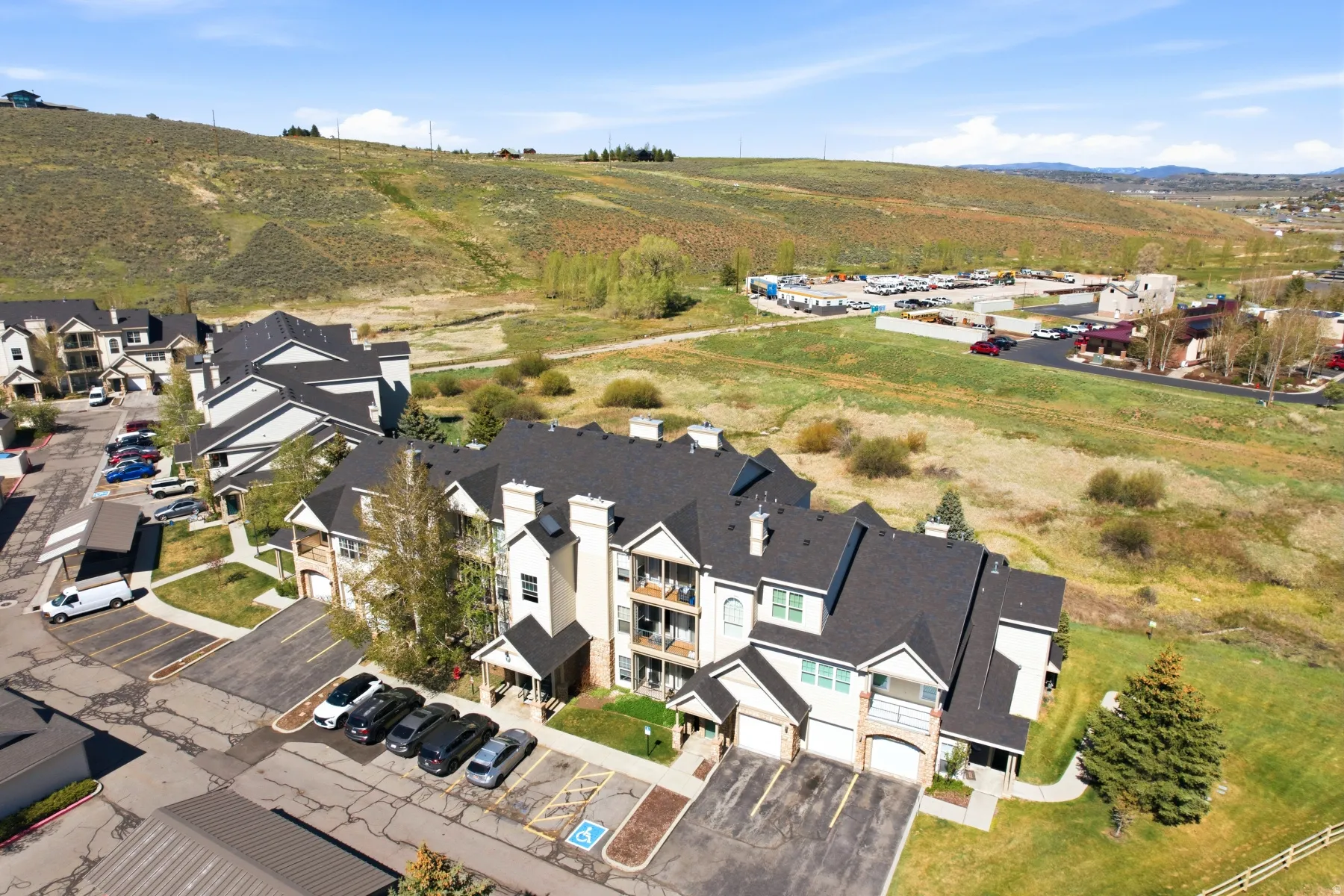 Multi-story residential buildings with dark shingle roofs and light-toned siding