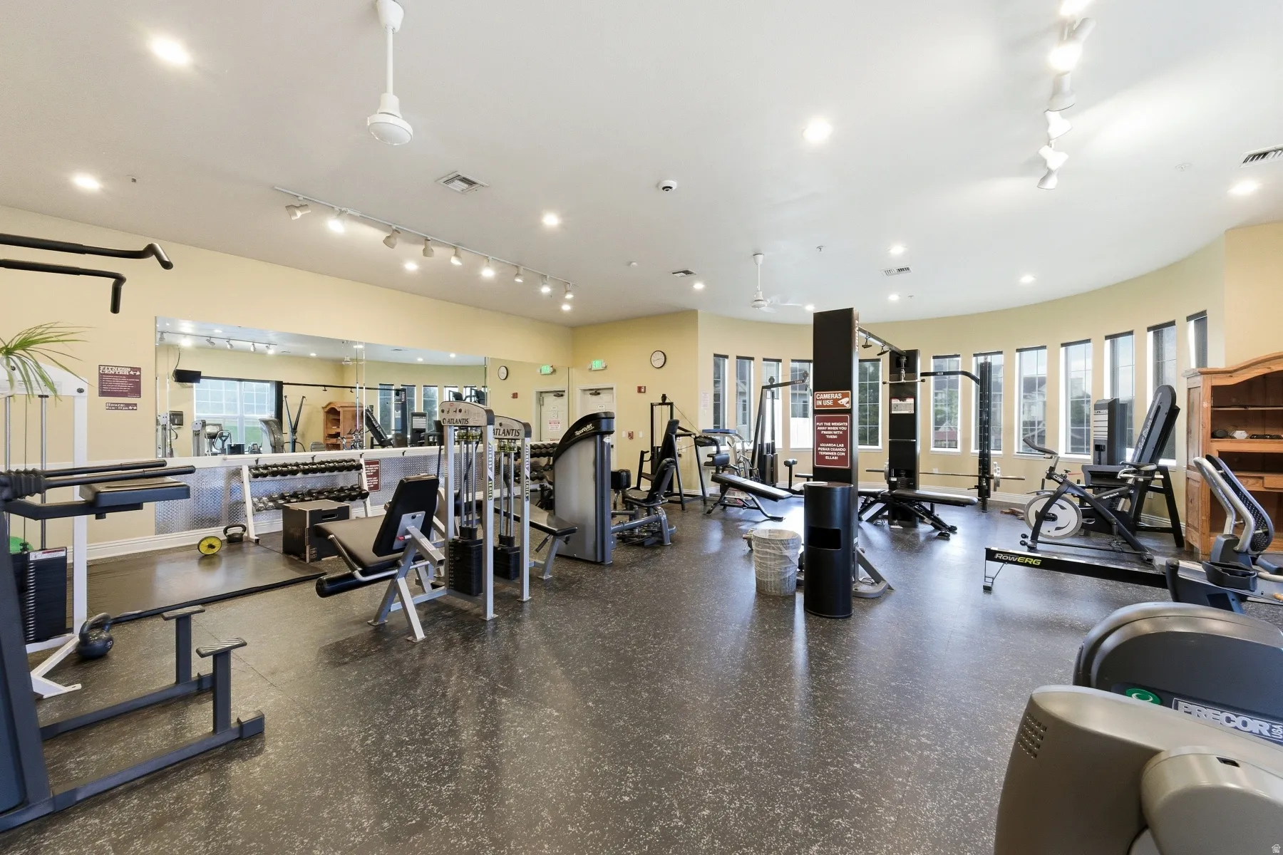 Spacious fitness center featuring a variety of exercise equipment, mirrored wall, recessed lighting, and ceiling fans