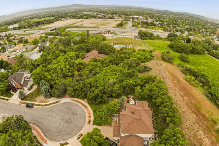 Expansive aerial view showcasing a cul-de-sac with mature landscaping and surrounding residential properties