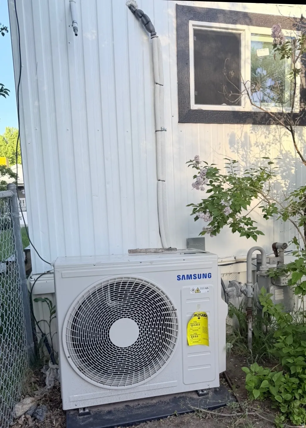 White vertical siding exterior with a Samsung mini-split HVAC unit