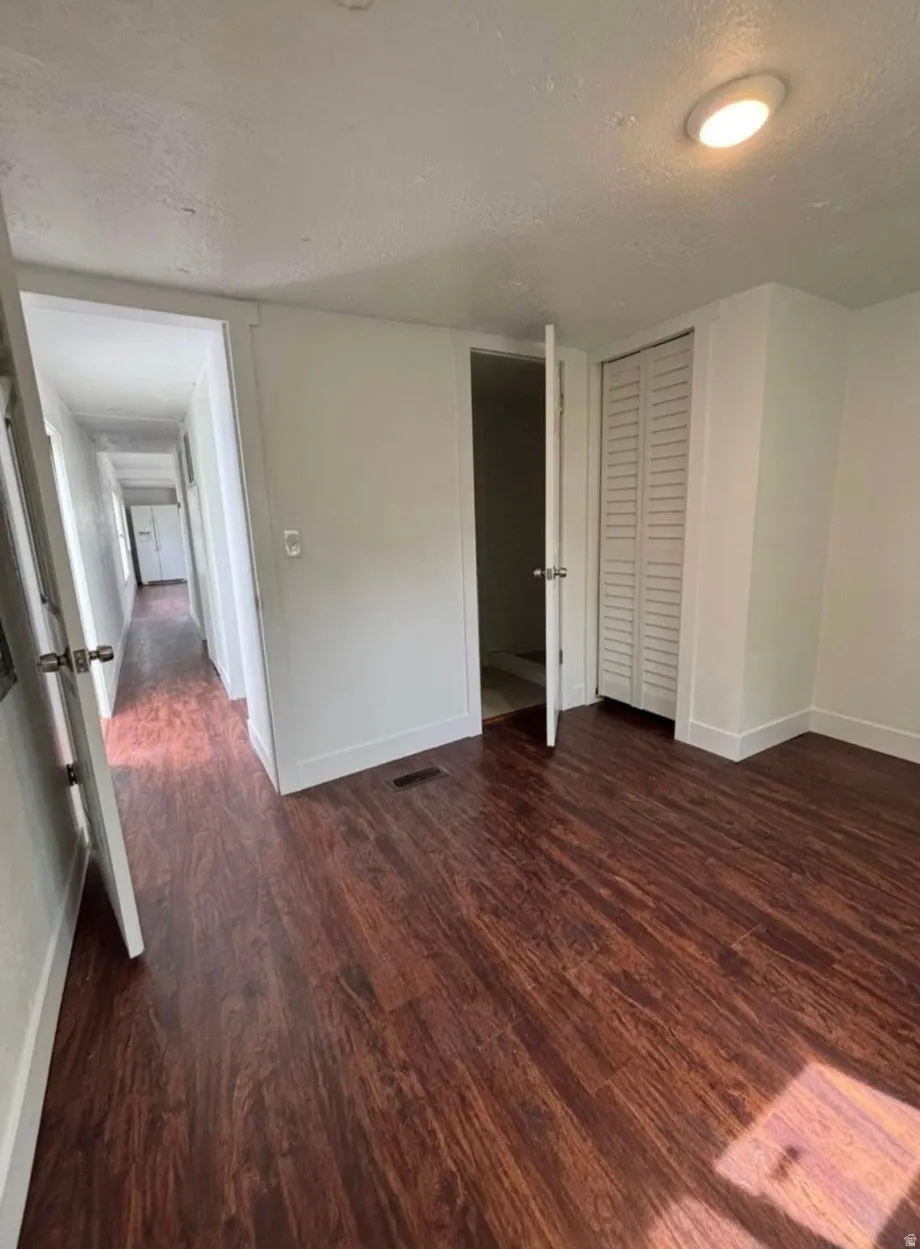Room featuring wood-finish flooring, white walls, and a recessed ceiling light