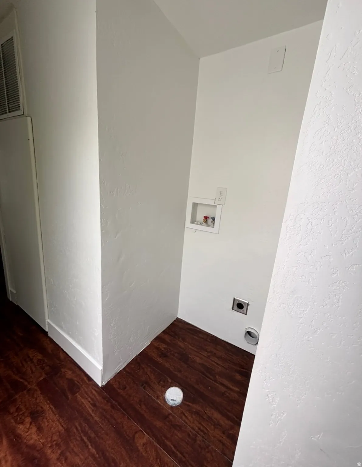 Dedicated laundry area featuring wood-finish flooring and white walls