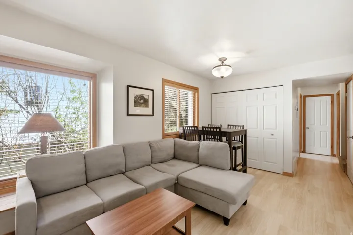 Living area featuring wood-finish flooring, a large picture window with wood trim, and a built-in window sill