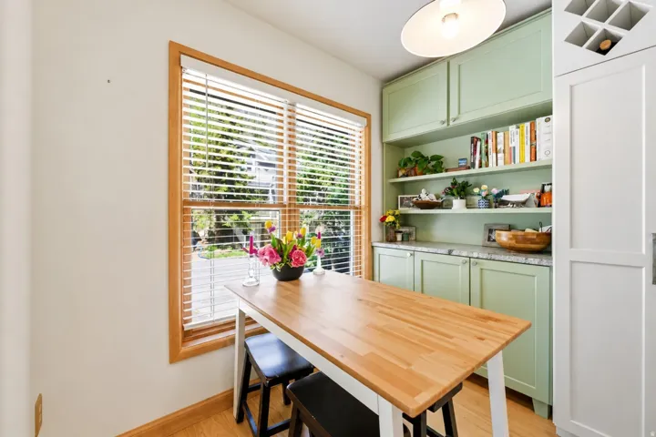 Breakfast nook featuring natural wood flooring and a large window with wood blinds