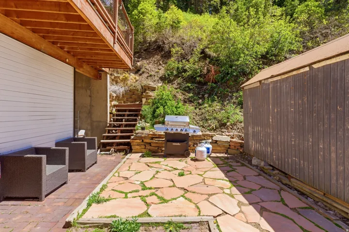 Outdoor patio with flagstone flooring, brick pavers, and natural stone retaining walls