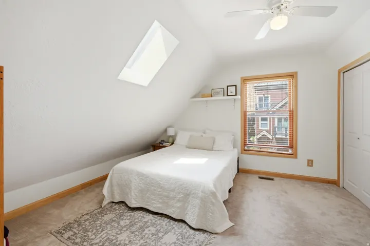 Carpeted bedroom featuring a sloped ceiling and a skylight