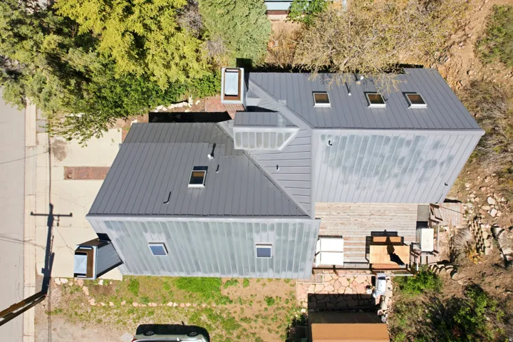 Modern construction featuring a multi-level metal roof with multiple skylights