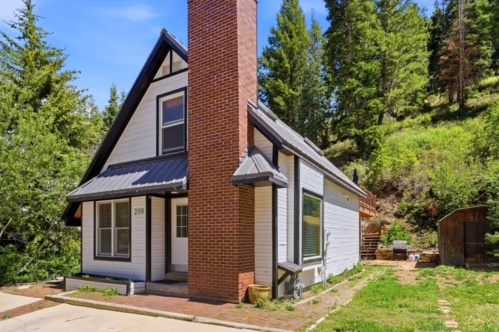 A-frame style exterior with white siding and dark trim