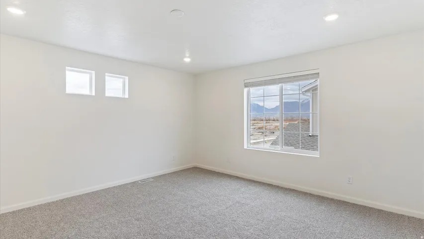 Wall-to-wall carpeting and white walls featuring recessed lighting