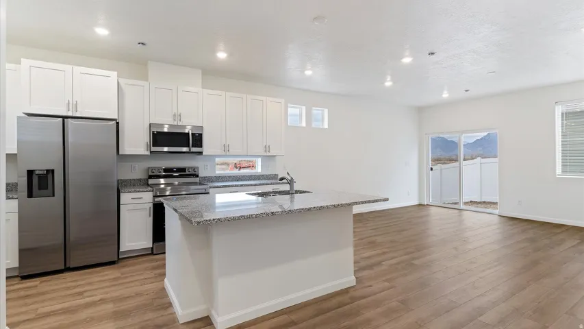 Modern kitchen and open-concept living space with wood-finish flooring
